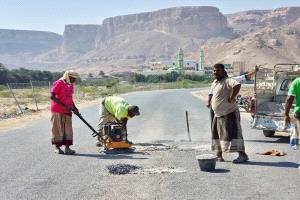 فريق الصيانة بمكتب الاشغال العامة والطرق بمديرية القطن يقوم بأعمال ردم الحفر في الاسفلت داخل المدينة و السوق التجاري